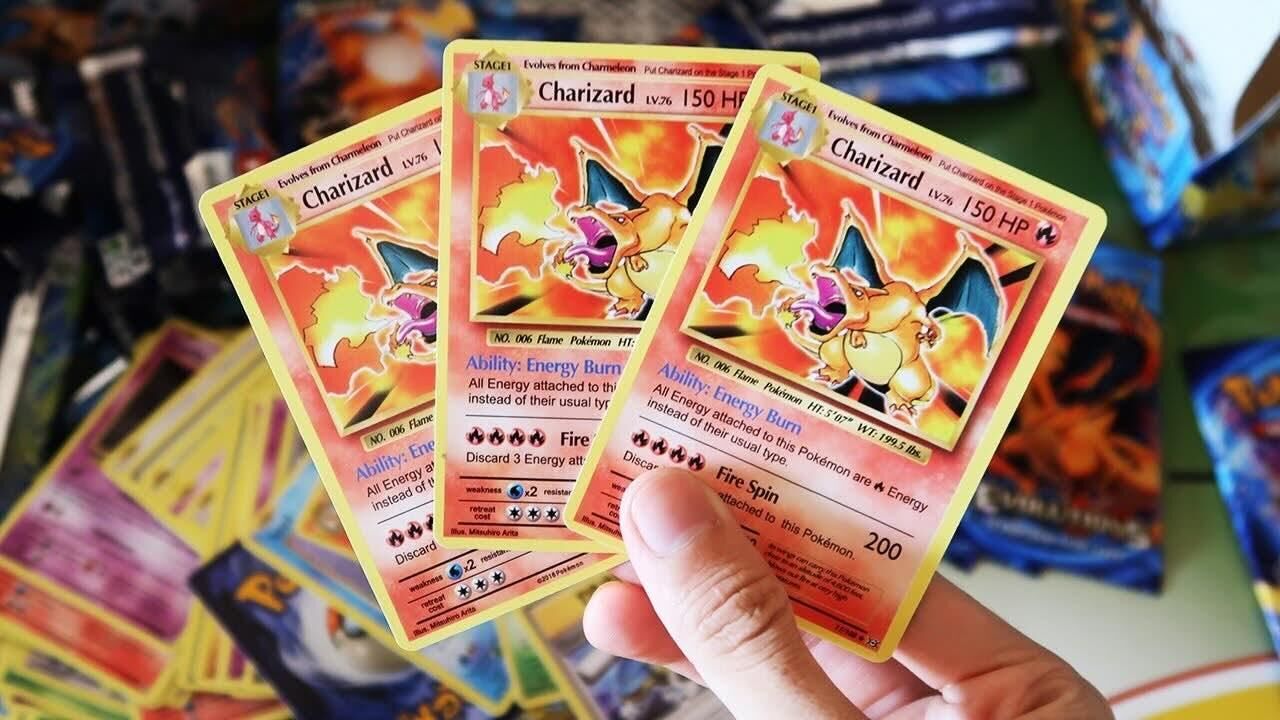 Drei Charizard-Karten im Retro-Design der Serie XY Evolutions in einer Hand, Motiv zum Erkennen gefälschter Karten