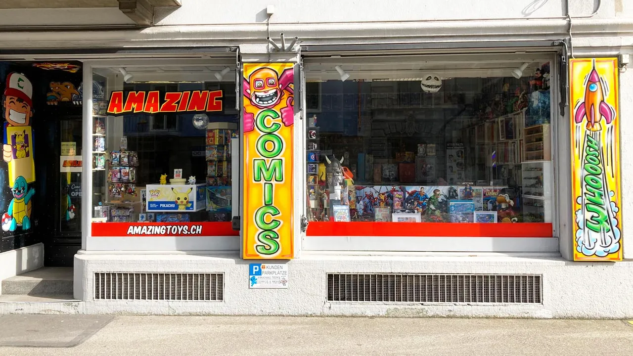Erstaunlicher Jahresrückblick im Amazing Schaufenster des AMAZINGTOYS® Store in Zürich mit rotem AMAZING-Schriftzug und gelbem COMICS-Schild
