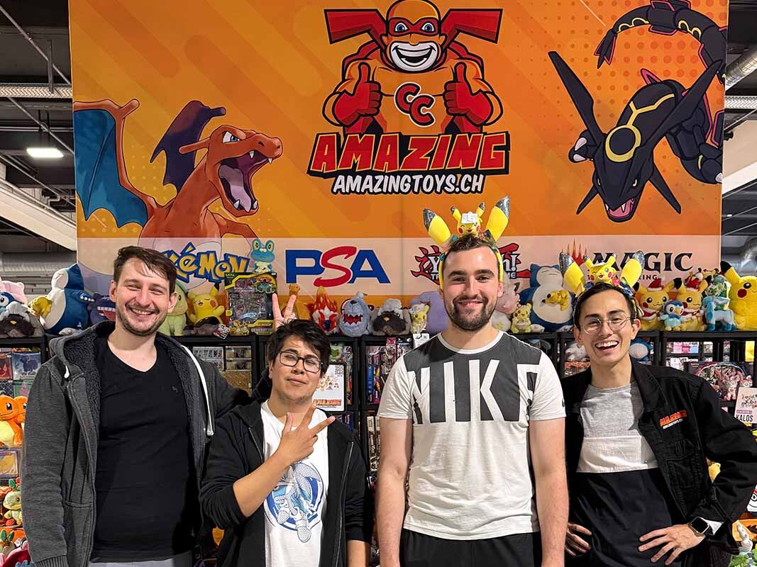 Zürich Pop Con 2024 x AMAZINGTOYS® Vier Personen vom AMAZINGTOYS® Team vor der Standwand mit Glurak-Motiv an der Zürich Pop Con